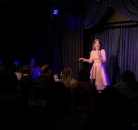 a woman in a dress standing in front of a crowd