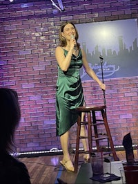 a woman in a green dress singing on stage