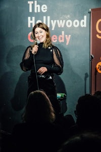 a woman speaking into a microphone at the hollywood comedy