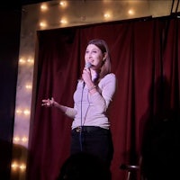 a woman is standing in front of a microphone