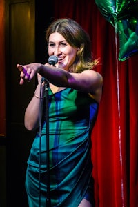 a woman in a green dress singing into a microphone